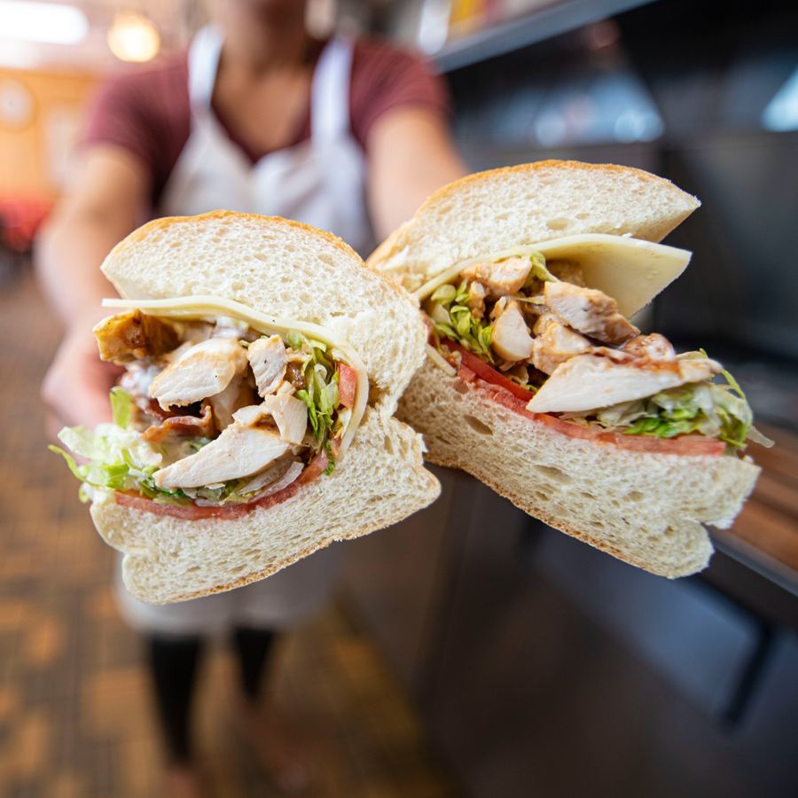 Chicken Bacon Ranch sub showing sliced grilled chicken, crispy bacon, melted provolone, lettuce, tomato, and ranch dressing