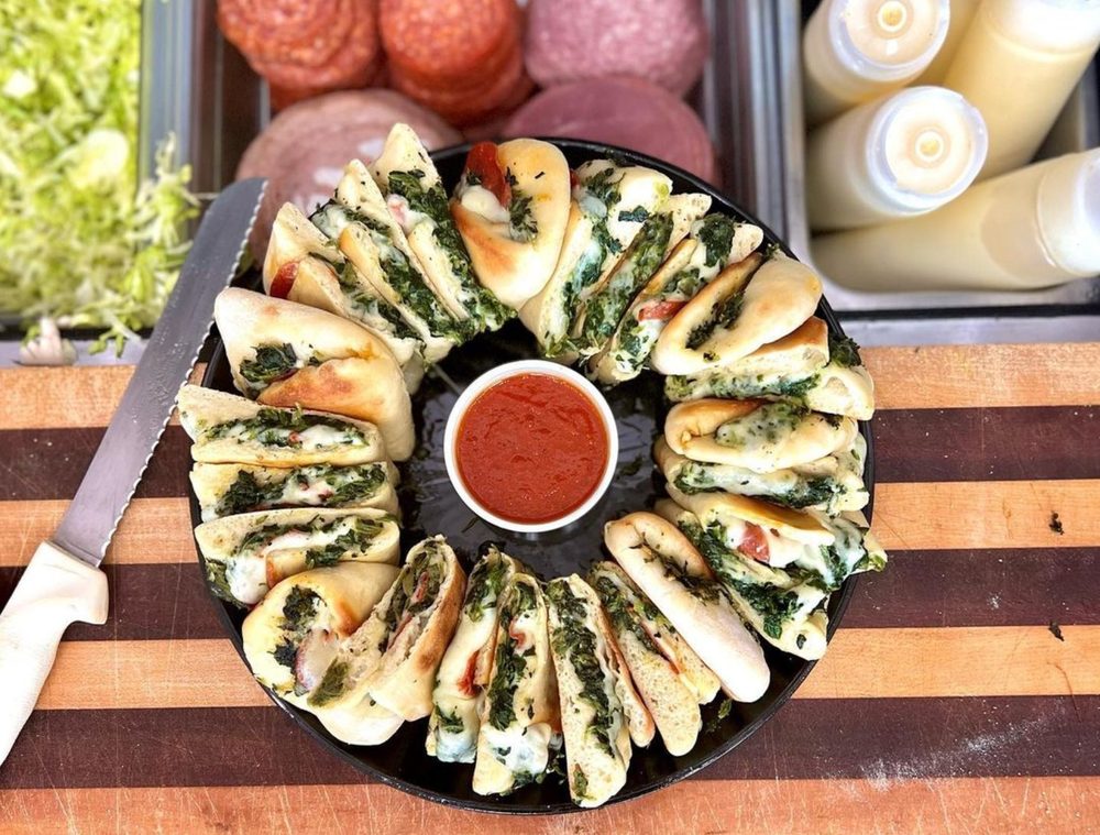 Famous Pie Platter with spinach pies arranged in a circle around a marinara dipping cup, feeds 10 people